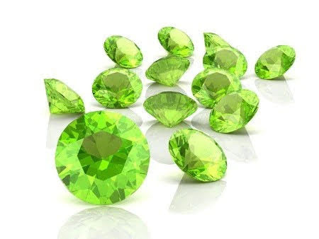 Small, vibrant green peridot gemstones on a white background, perfect for handmade jewelry and August birthstone gifts. Natural peridot stones showcasing clarity and brilliance."