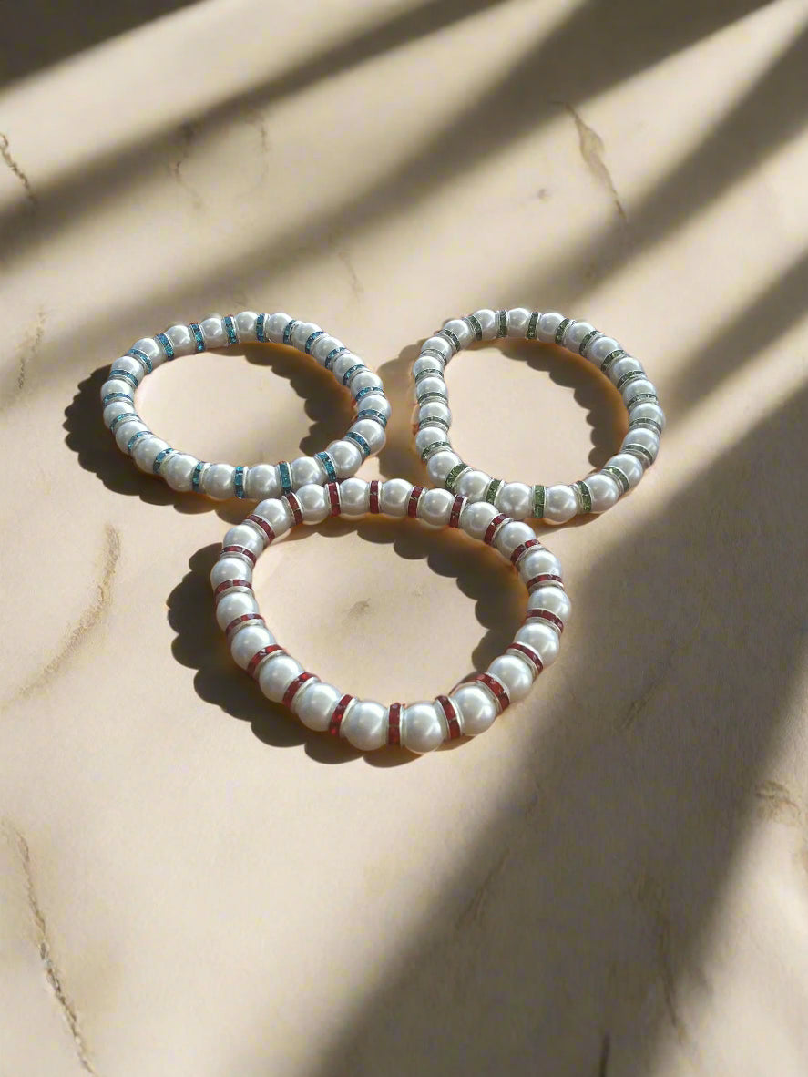 A set of 6-inch stretch bracelets featuring white faux pearls with sparkling blue, green, and red accent beads. Lightweight, stackable, and perfect for everyday wear or gift giving.