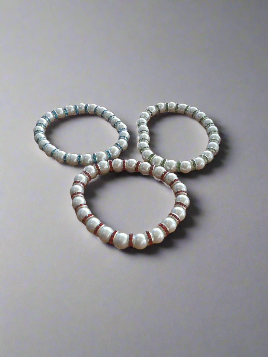 A set of 6-inch stretch bracelets featuring white faux pearls with sparkling blue, green, and red accent beads. Lightweight, stackable, and perfect for everyday wear or gift giving.