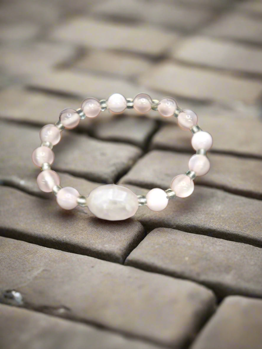 A 6-inch stretch bracelet featuring 6mm natural rose quartz beads with a cat’s eye focal bead. A soft pink, elegant piece symbolizing love, healing, and strength.