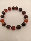 Bracelet with brown and red beads on a white background