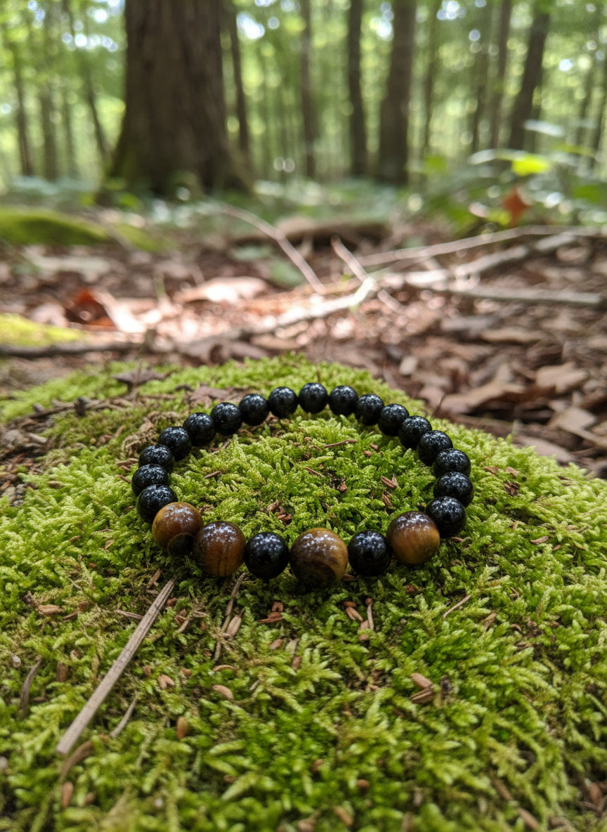 Beaded bracelet with black and brown beads on a forest background