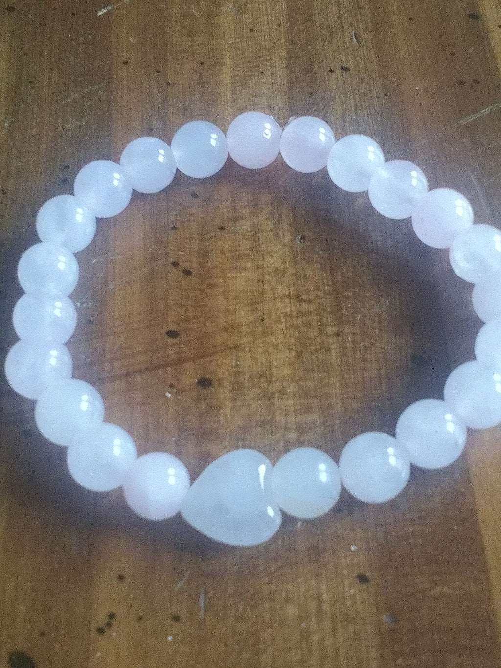 Pink beaded bracelet on a wooden surface