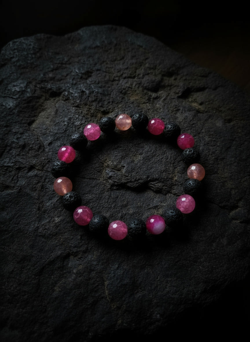 Bracelet with red and black beads on a rock surface