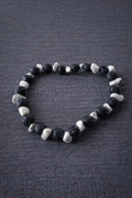 Black and white beaded bracelet on a textured gray surface