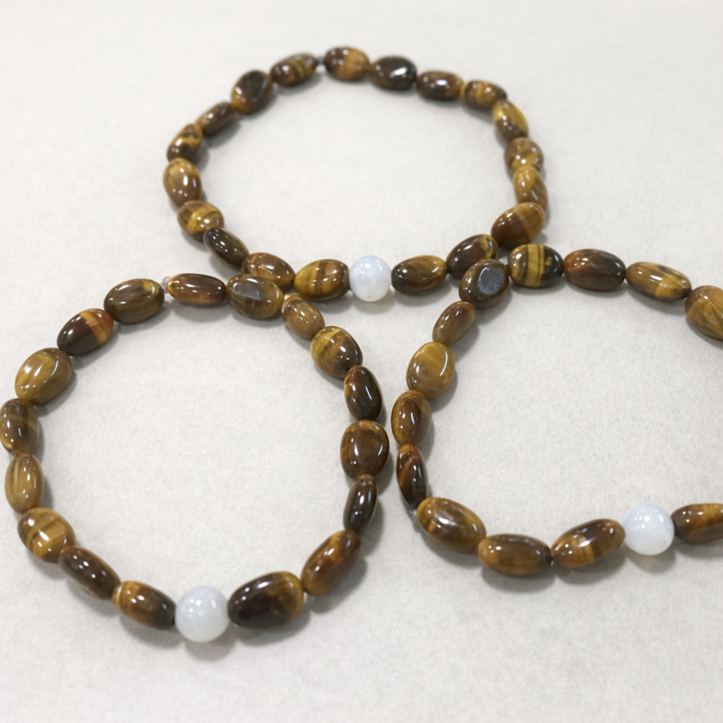 Beaded necklace with brown and white beads on a light background