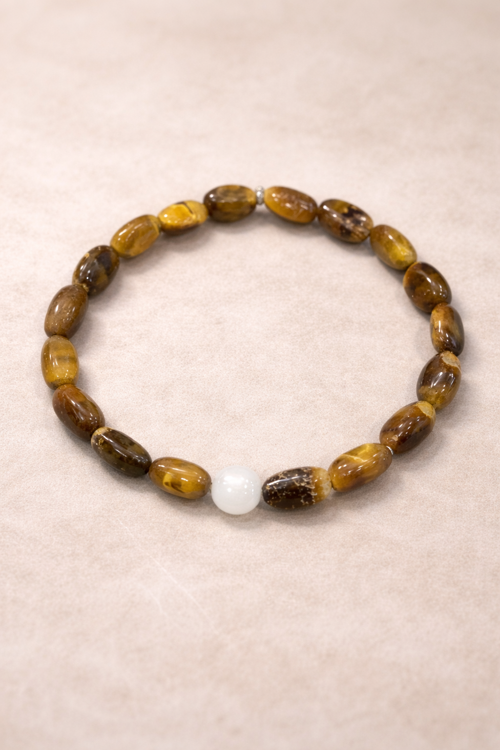 Bracelet with brown and yellow beads on a beige background