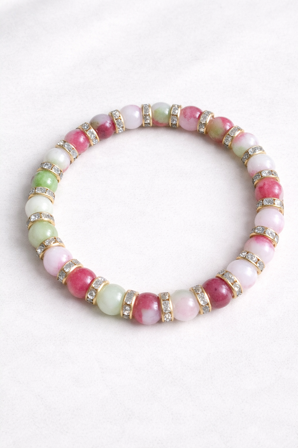 Multicolored beaded bracelet with gold accents on a white background