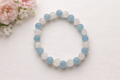 Beaded bracelet with blue and white beads on a light background with flowers.