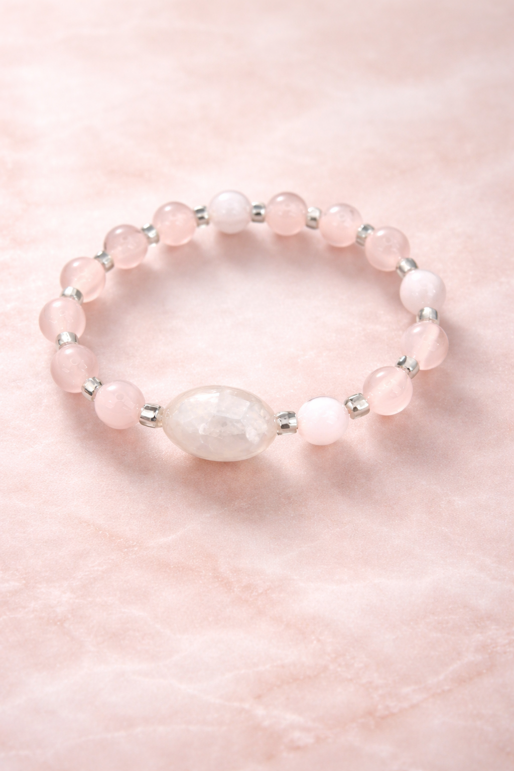 Rose quartz and cat’s eye stretch bracelet with soft pink gemstone beads and a glowing focal bead