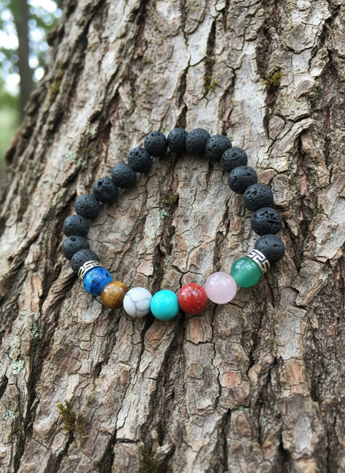 Beaded bracelet with multicolored beads on a rugged tree trunk