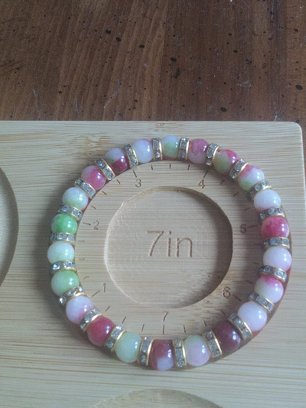 Watermelon tourmaline bracelet on a wooden 7" bracelet sizer with sparkle beads.